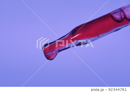 Pipette with dragon's blood. Highlighted on a lilac background, the colors of the year 2022. The concept of blood analysis for cosmetology. An ingredient of natural cosmetics. High quality photo 92344761