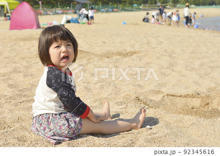 砂浜に座って泣いている女の子 砂浜に座って泣いている女の子 92345616
