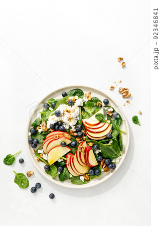 Apple and spinach fresh sweet fruit salad with blueberry, cheese cottage and walnuts, top view 92346841