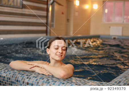 Young woman wearing swimsuit swimming indoors swimming pool Young woman wearing swimsuit swimming indoors swimming pool 92349370