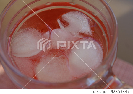 Glass of Roselle juice with ice. Traditional beverage. Herbal drink. Top view on wooden table. Glass of Roselle juice with ice. Traditional beverage. Herbal drink. Top view on wooden table. 92353347