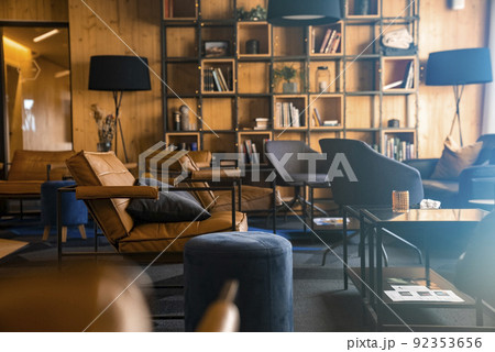 Chairs and table arranged against bookshelf in beautiful luxurious hotel lobby 92353656