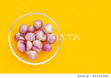Fresh shallot in glass bowl on yellow background 92354280