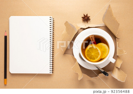 Cup of tea with lemon and honey on torn paper. Mug full of tea Cup of tea with lemon and honey on torn paper. Mug full of tea 92356488