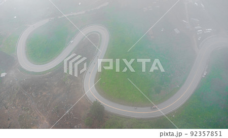 Aerial drone top view of a road curve winding through the mountains Aerial drone top view of a road curve winding through the mountains 92357851