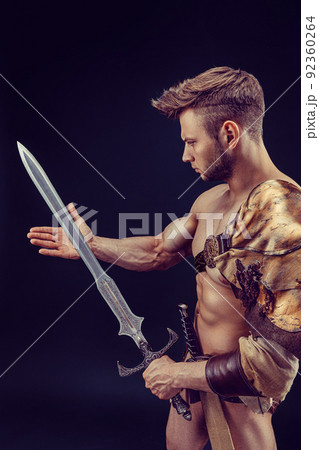 Portrait of handsome muscular gladiator with sword. Isolated. Studio shot. Portrait of handsome muscular gladiator with sword. Isolated. Studio shot. 92360264