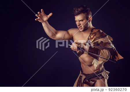 Portrait of handsome muscular gladiator with sword. Isolated. Studio shot.  92360270