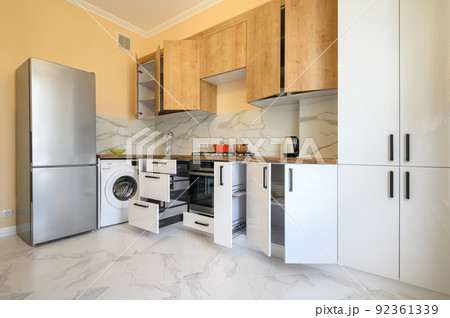 White and yellow wooden modern kitchen interior, some drawers open White and yellow wooden modern kitchen interior, some drawers open 92361339