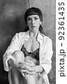 A sensual portrait of a girl with an emotional face and sensual eyes in a white shirt. 92361435