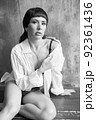 A sensual portrait of a girl with an emotional face and sensual eyes in a white shirt. 92361436