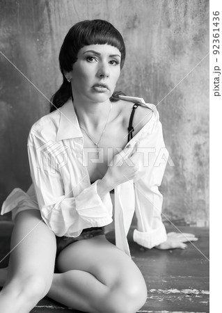 A sensual portrait of a girl with an emotional face and sensual eyes in a white shirt. 92361436