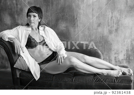 A sensual portrait of a girl with an emotional face and sensual eyes in a white shirt. A sensual portrait of a girl with an emotional face and sensual eyes in a white shirt. 92361438