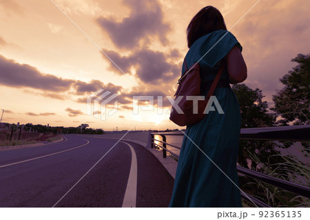 夕暮れにたたずむ女性の写真素材 [92365135] - PIXTA