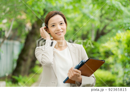 新緑の中で微笑む社会人女性 92365815