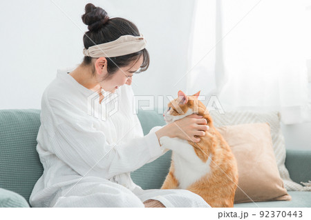 家で猫と遊ぶ日本人女性(嫌がる・抱っこ嫌い) 家で猫と遊ぶ日本人女性(嫌がる・抱っこ嫌い) 92370443