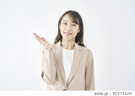 掌で左側を指すビジネスウーマン　白バック 92371320