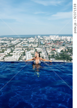 Woman in swimming pool on roof 92371539