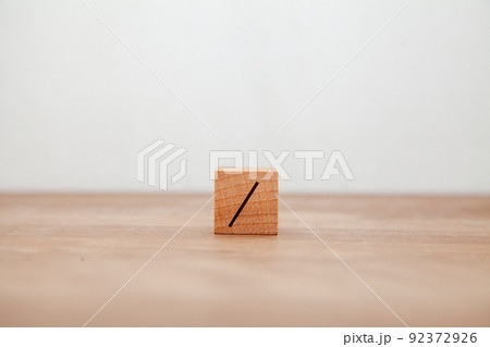 /の文字。分ける。割り算。除法。木製ブロックに書かれている。黒い文字。木製テーブルの背景。 /の文字。分ける。割り算。除法。木製ブロックに書かれている。黒い文字。木製テーブルの背景。 92372926