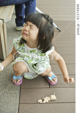 おにぎりを落として泣いている女の子 92374896