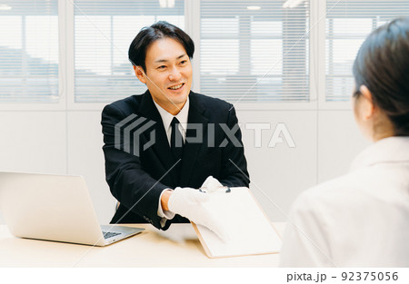 契約書にサインを求める白手袋をつけたビジネスマン（鑑定士・質屋・男性） 92375056