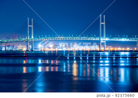 水面に輝く首都高速湾岸線横浜ベイブリッジのイルミネーションが美しい夜景｜神奈川県横浜市 92375660
