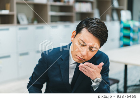 仕事中に手の平のにおいを嗅ぐ男性 仕事中に手の平のにおいを嗅ぐ男性 92376469