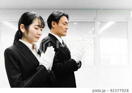 白手袋をつけて合掌するスーツ姿の男女（葬祭ディレクター・お葬式） 92377028