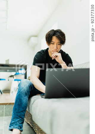 リビングで仕事をする若い男性 92377330