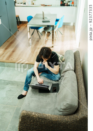 リビングで仕事をする若い男性 92377335