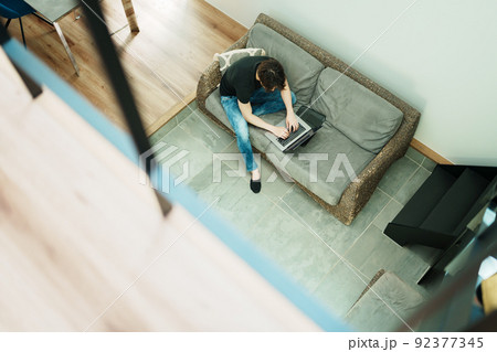 リビングで仕事をする若い男性 92377345
