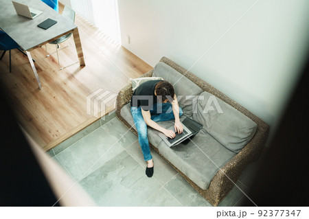 リビングで仕事をする若い男性 92377347