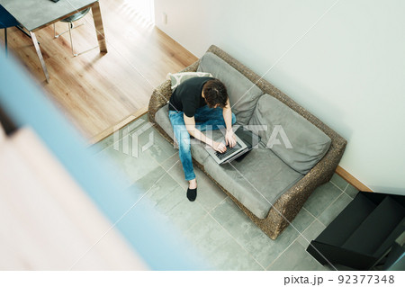 リビングで仕事をする若い男性 92377348