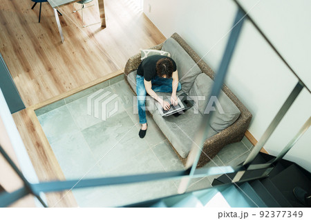 リビングで仕事をする若い男性 92377349