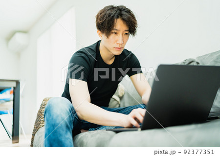 リビングで仕事をする若い男性 92377351