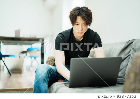 リビングで仕事をする若い男性 92377352