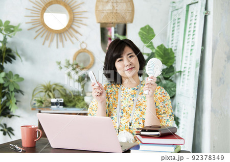 女性　テレワーク　節電　携帯扇風機　カメラ目線 92378349