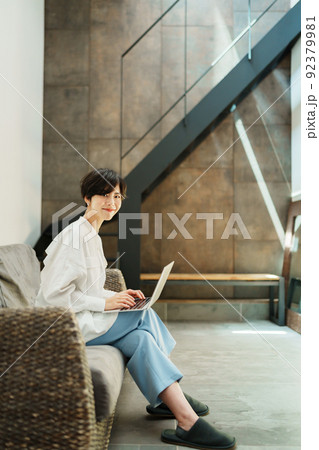 おしゃれなリビングでテレワークする女性 92379981