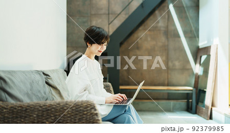 おしゃれなリビングでテレワークする女性 92379985