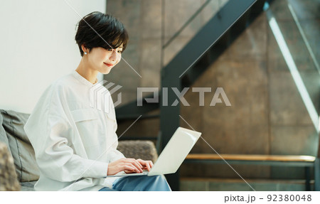 おしゃれなリビングでテレワークする女性 92380048