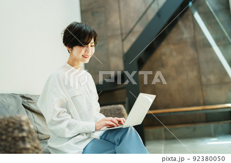 おしゃれなリビングでテレワークする女性 92380050