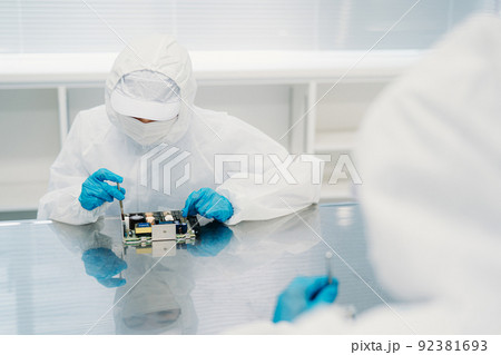 クリーンルームで精密機器を扱う女性 92381693