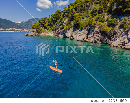 Young women Having Fun Stand Up Paddling in blue water sea in Montenegro. SUP. girl Training on Paddle Board near the rocks Portrait of a disgruntled girl sitting at a cafe table Young women Having Fun Stand Up Paddling in blue water sea in Montenegro. SUP. girl Training on Paddle Board near the rocks Portrait of a disgruntled girl sitting at a cafe table 92384669