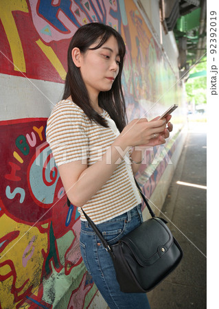 高架下歩道の入り口に立つ女性 92392019