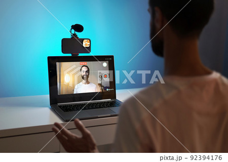A young blogger records a video with himself on his phone in his studio. 92394176