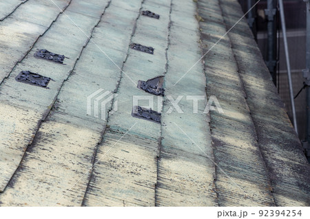 築25年の一戸建ての、色あせて汚くなったメンテナンスの必要な屋根 92394254