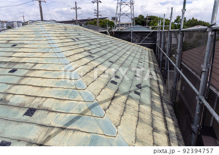築25年の一戸建ての、色あせて汚くなった屋根の葺き替え工事をするために足場を立てたところ 築25年の一戸建ての、色あせて汚くなった屋根の葺き替え工事をするために足場を立てたところ 92394757