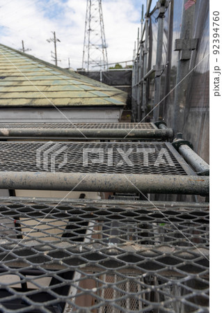 築25年の一戸建ての、色あせて汚くなった屋根の葺き替え工事をするために足場を立てたところ 92394760