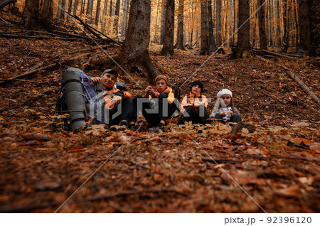 Portrait of a family sitting down to rest during a hike in the mountains. 92396120