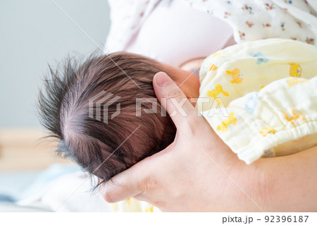母乳を飲む新生児の写真。子育てのイメージ。 92396187