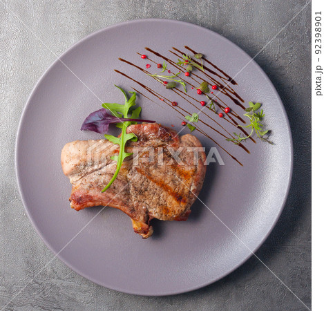 roast pork steak decorated with herbs. top view roast pork steak decorated with herbs. top view 92398901